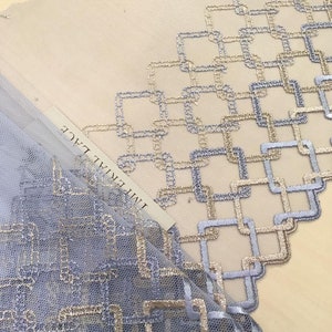 May include: Light blue and gold geometric lace fabric with the text "Imperial Lace" printed on a white tag.