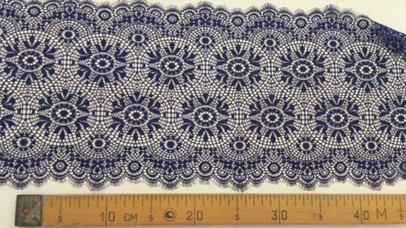 May include: Navy blue lace trim with a delicate floral pattern. The trim is approximately 40 inches long and has a scalloped edge.