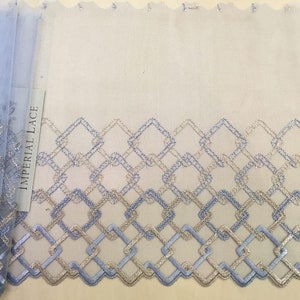 May include: Blue and gold geometric lace trim with a scalloped edge. The trim features a repeating pattern of squares and diamonds. The label reads "Imperial Lace".