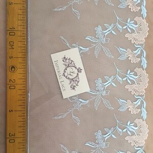 K&ouml;nnte beinhalten: Hellblaue und wei&szlig;e florale Spitzenborte mit einem gewellten Rand. Die Spitze befindet sich auf einem beigefarbenen Hintergrund und ist 20 cm lang. Der Text "Imperial Lace" ist auf einer wei&szlig;en Karte sichtbar.