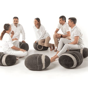 felted poufs by KATSU are arranged in a circle, people dressed in white are sitting on them