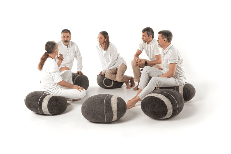 felted poufs by KATSU are arranged in a circle, people dressed in white are sitting on them