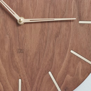 Mid century modern clock. Dark brown colour of the clock made of american walnut wood. This would perfectly fit to modern and minimalist like interior.