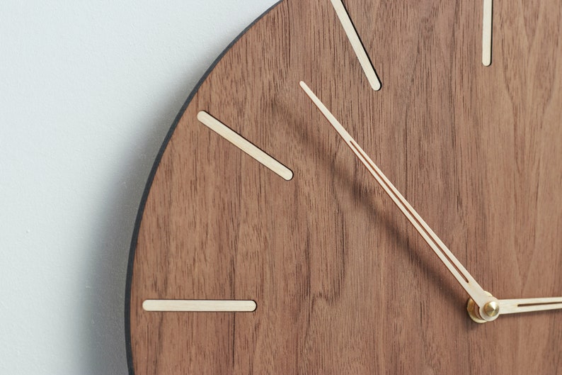 Wall clock made of american walnut wood. Shape of clock hands make reading time easy whilst ensuring the look of the clock to be great