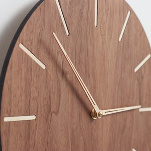 Wood wall clock made of american walnut. Minimalist design mid century modern wall clock. Easy to read the time. Equipped with a silent clock mechanism.The clock is perfect for bedroom, office or living room