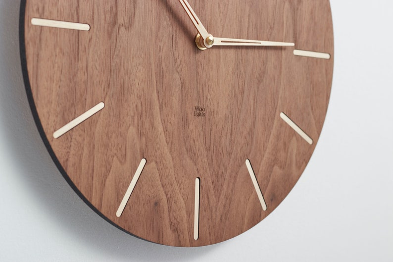 Details of the wooden wall clock. Unique and intriguing arrangement of wood grain gives each clock a distinctive character. The balanced contrast between the clock face and the indexes makes it easier to read the time while ensuring an elegant look.