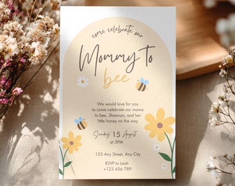 Puede incluir: Una invitación de baby shower de color beige claro con las palabras "Mommy to bee" en una fuente de escritura. La invitación incluye flores amarillas, abejas y detalles del evento. El texto dice "Sunday 15 August at 3PM".