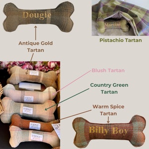 May include: A collection of dog chew toys made from tartan fabric. The toys are shaped like bones and have different names embroidered on them, including "Dougie", "Martini", and "Billy Boy".