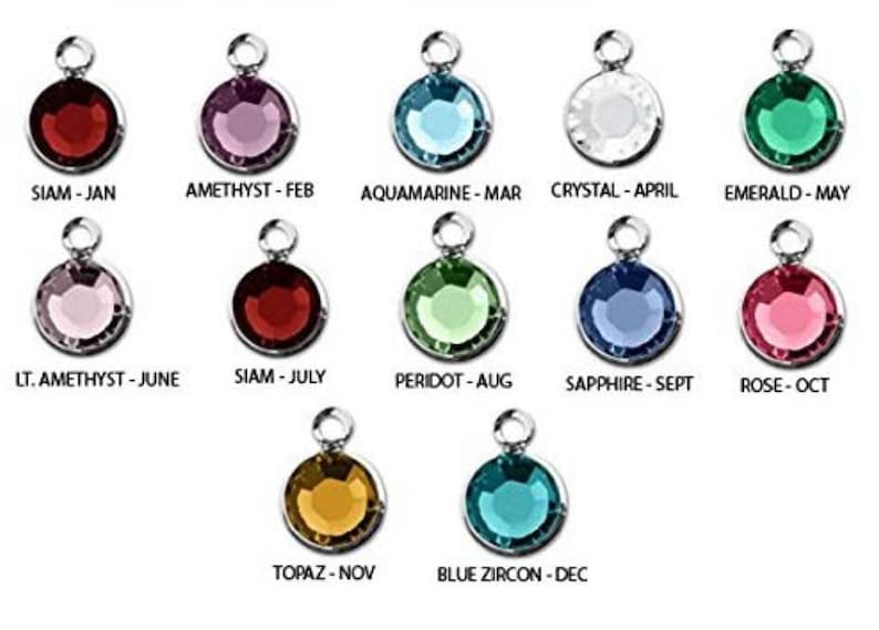 May include: Twelve silver charms with different colored gemstones, each representing a month of the year. The charms are labeled with the gemstone name and month.