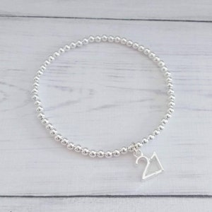 May include: A silver beaded bracelet with a silver charm that says "21".