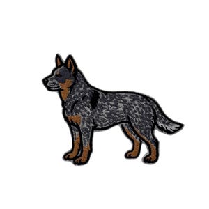May include: An embroidered patch featuring a standing Australian Cattle Dog in profile. The dog has a mottled blue-grey coat with tan markings on the face, chest, and legs, outlined in black thread against a white background.