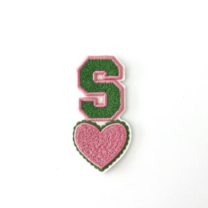 May include: Green felt letter S with pink felt outline, topped with a pink felt heart with white felt outline.