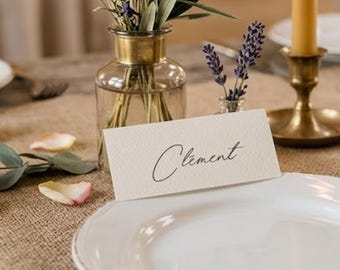 Personalized wedding place card with calligraphic font, on beautiful textured paper.