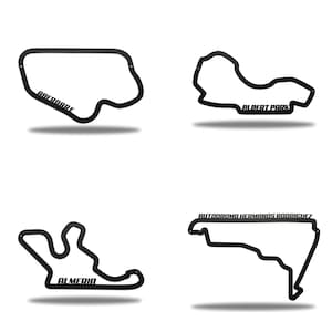 May include: Four black metal wall art pieces showing race track layouts. Each piece features a different track: Aberdare, Albert Park, Almeria, and Autodromo Hermanos Rodriguez. The track names are displayed in a bold, sans-serif font.