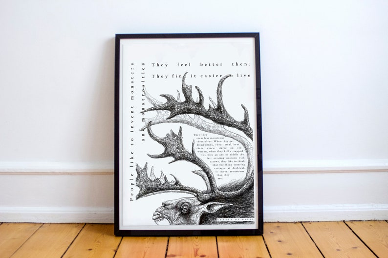 May include: Black and white framed art print featuring a detailed illustration of a moose with large antlers. The artwork includes text that reads "They feel better then. They find it easier to live."