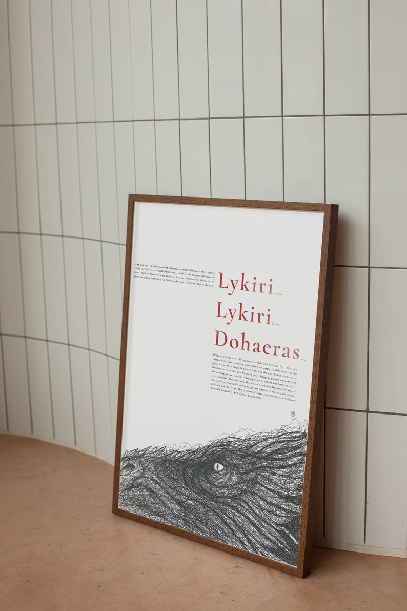 Pu&ograve; includere: Una stampa incorniciata con un'illustrazione in bianco e nero di un occhio di drago. La stampa presenta il testo "Lykiri Lykiri Dohaeras" in rosso.