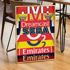 May include: A framed poster with a colorful design featuring the words "Dreamcast", "SEGA", and "Emirates" repeated in different colors and sizes.