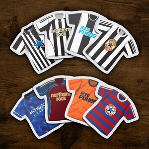 Op de afbeelding: Een set van tien zwarte en witte onderzetters in de vorm van voetbaltruien met verschillende sponsors, waaronder "northern rock" en "FUN88".