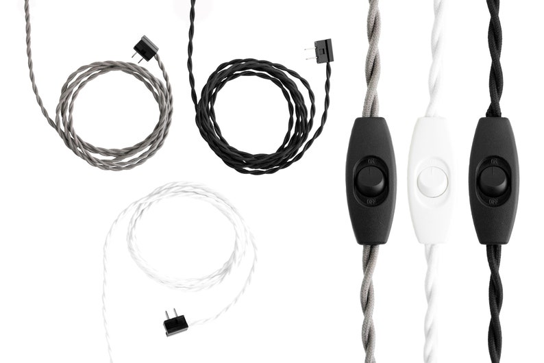 May include: Three twisted fabric electrical cords in gray, black, and white. Each cord features a two-prong plug at one end and an inline rocker switch in the center. The switches are black for the gray and black cords, and white for the white cord.
