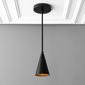 May include: A black pendant light with a cone-shaped shade. The light is suspended from a black cord and has a round ceiling mount.