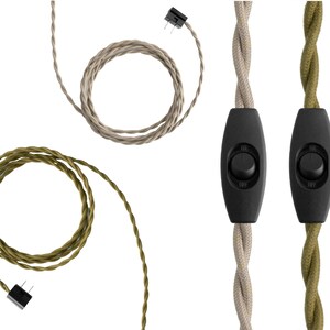 May include: Two twisted fabric-covered electrical cords, one beige and one olive green, each featuring a black inline rocker switch with on and off markings and a two-prong plug connector at the end of the coiled cord sections.