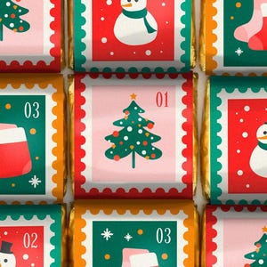 Puede incluir: Un conjunto de nueve barras de chocolate con temática navideña con diseños festivos. Cada barra presenta un diseño diferente, incluyendo un árbol de Navidad, un muñeco de nieve y una media. Las barras están envueltas en papel de aluminio dorado y tienen un borde rojo y verde.