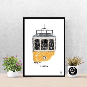 May include: A black framed print of a yellow tram with a map of Lisbon, Portugal, inside. The tram is outlined in black and the map is in shades of gray. The word "LISBOA" is printed in black at the bottom of the print.