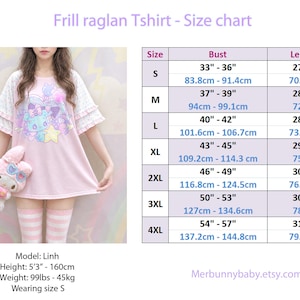 May include: A light pink frill raglan t-shirt with short layered sleeves and a graphic print of a blue creature, stars, and hearts. The image includes a size chart with bust and length measurements in inches and centimetres for sizes S to 4XL.