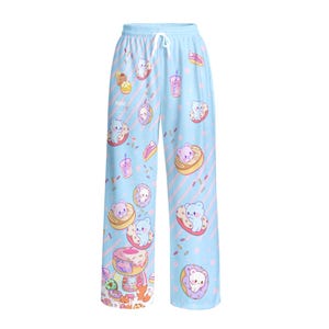 May include: Light blue lounge trousers featuring a repeating pattern of small cartoon bears, doughnuts, and pink drinks. The trousers have a white drawstring at the elastic waistband and diagonal pink stripes across the fabric, with colourful sprinkles.