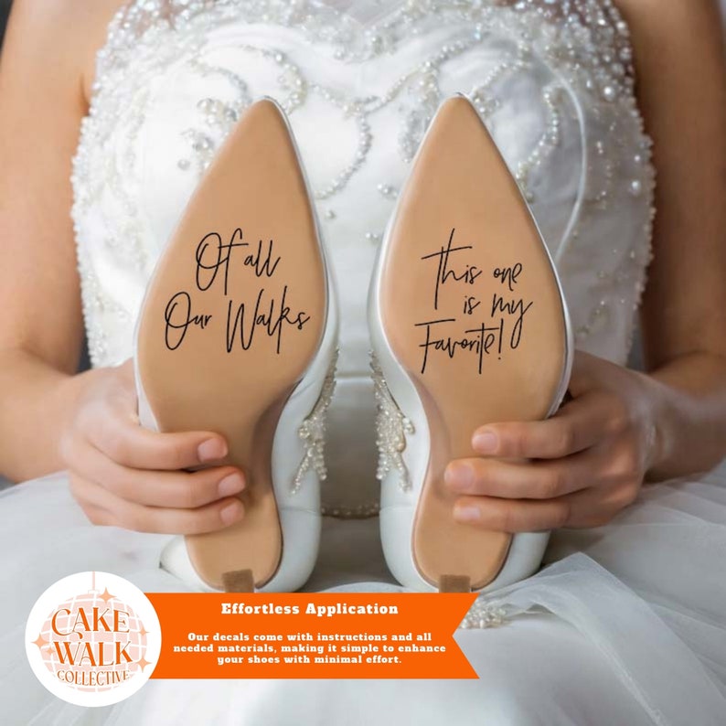 May include: A pair of white bridal shoes with a brown sole. The soles have black lettering that reads "Of all our walks" and "This one is my favourite!"  The shoes are held by a person's hands. The image includes a logo for "Cake Walk Collective" and the text "Effortless Application. Our decals come with instructions and all needed materials, making it simple to enhance your shoes with minimal effort."
