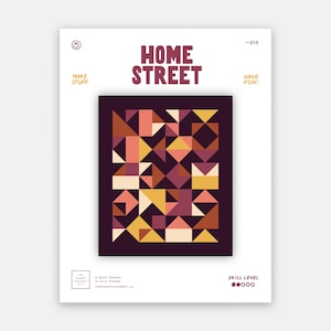 Könnte beinhalten: Ein Quiltmuster mit dem Titel HOME STREET, das eine zentrale Grafik aus geometrischen Formen in Dunkelviolett, Orange, Gelb und Creme zeigt. Das weiße Cover enthält den Text MAKE STUFF, HAVE FUN und eine Anzeige für den Schwierigkeitsgrad.