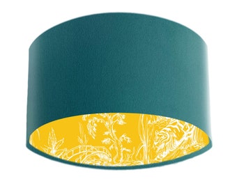 May include: Teal lampshade with a yellow and white floral pattern on the inside.