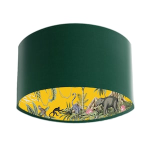 May include: A green lampshade with a yellow, jungle-themed lining. The lining features monkeys, an elephant, and tropical plants.