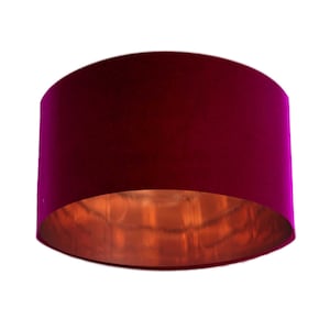 May include: A round, fuchsia pink velvet lampshade with a copper interior.