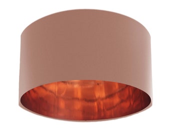 May include: A dusty rose lampshade with a copper interior. The lampshade is cylindrical and has a smooth finish.