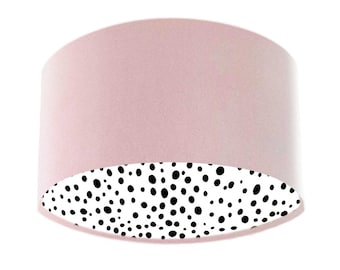 May include: A pink lampshade with a white and black polka dot pattern on the inside.