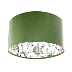 May include: A green fabric lampshade with a white lining featuring a watercolor design of lemurs, flowers, and leaves.