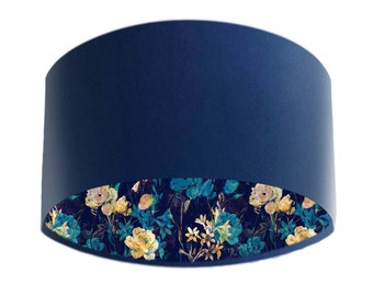 May include: A blue lampshade with a floral pattern on the inside. The floral pattern is in shades of yellow, green, and blue.