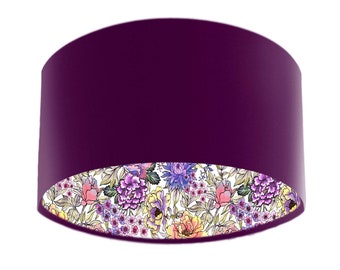 May include: A purple lampshade with a floral pattern on the inside. The floral pattern is in shades of pink, yellow, and blue.