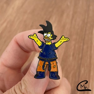 May include: A vibrant enamel pin depicting a cartoon character with black hair, yellow skin, and a blue top. The character wears orange trousers and is in a dynamic pose with arms outstretched. The pin is held in a hand.