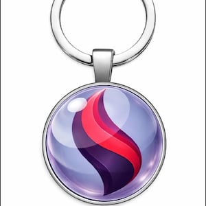 Puede incluir: Un llavero plateado con un colgante redondo que presenta un diseño abstracto púrpura y rojo. El colgante tiene un acabado transparente y brillante. El llavero es un accesorio sencillo y elegante.