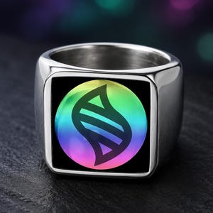 May include: A silver-toned metal signet ring featuring a square face with a circular inlay. The inlay displays a black graphic symbol resembling a stylized DNA strand set against a vibrant, multi-colored rainbow gradient background.
