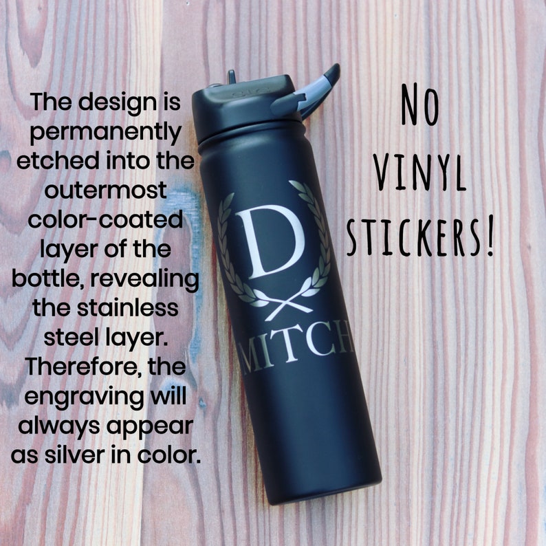 May include: A black stainless steel water bottle with a silver engraved design. The design includes a letter "D" inside a wreath with the name "MITCH" below. The text "NO VINYL STICKERS!" is written in white on a black background.