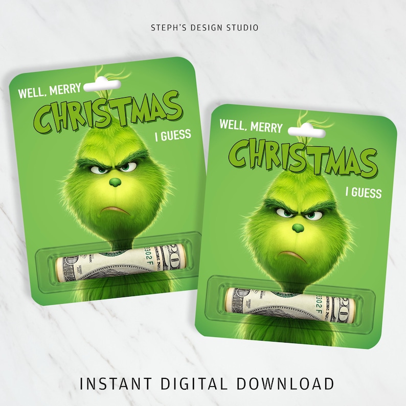 May include: Two green rectangular cards featuring a grumpy, furry green character with the text WELL, MERRY CHRISTMAS I GUESS. Each card has a clear plastic blister pack containing a rolled-up twenty-dollar bill. The cards are labeled STEPH'S DESIGN STUDIO.