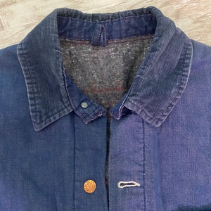 May include: A dark blue denim jacket with a corduroy collar. The jacket has a button closure and two pockets on the front.