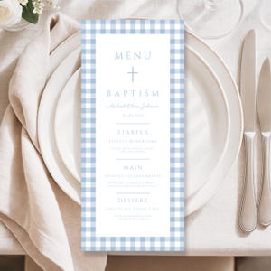 May include: A rectangular baptism menu card featuring a light blue and white gingham border. The center white panel displays the text MENU, BAPTISM, Michael Oliver Johnson, 01.25.2026, STARTER, MAIN, and DESSERT with associated food items.