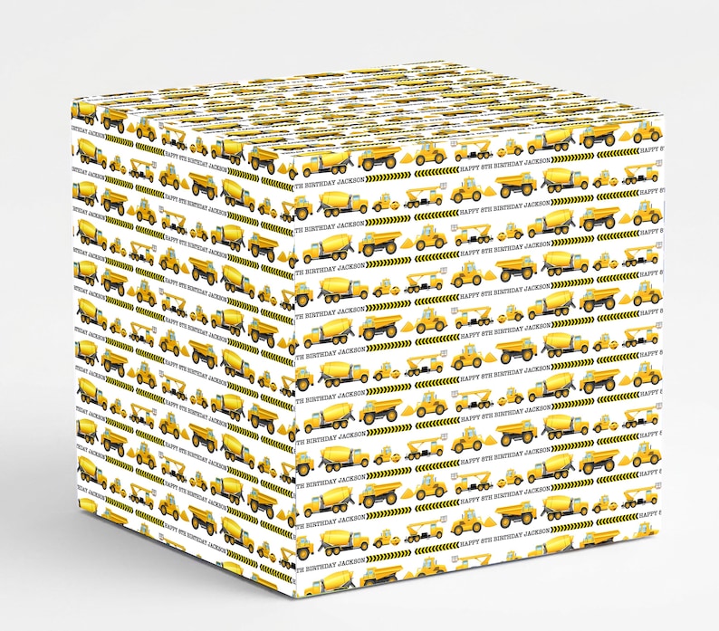 May include: White gift box wrapped in paper with a repeating pattern of yellow construction vehicles. The design includes dump trucks, cement mixers, and excavators. The text "HAPPY 8TH BIRTHDAY JACKSON" is also printed on the paper.