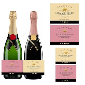May include: Two champagne bottles with gold and pink foil necks, each featuring a custom label. The labels are available in cream or pink, displaying the text CHAMPAGNE, MR & MRS JONES, CONGRATULATIONS, WEDDING 15/10/2023, and Lots of love Angela x.