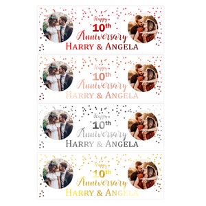 May include: A white banner with a couple's photo in a circle, confetti, and the text "Happy 10th Anniversary HARRY & ANGELA". The confetti is in red, rose gold, silver, and gold.