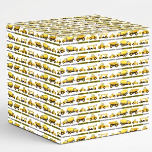 May include: White gift box wrapped in paper with a repeating pattern of yellow construction vehicles. The design includes dump trucks, cement mixers, and excavators. Text reads "HAPPY 8TH BIRTHDAY JACKSON".